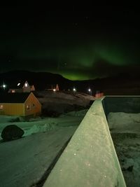 Illuminated road against sky at night during winter