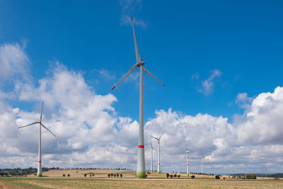 Wind turbine on field against sky