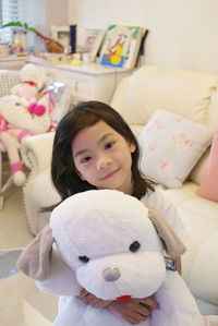 Portrait of cute girl with toy at home