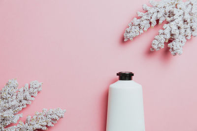 High angle view of bottles on pink background