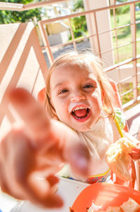 Portrait of young woman sitting on railing