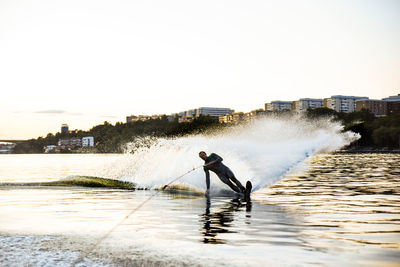 Man waterskiing on sea against sky