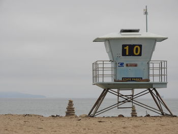 Lifeguard hut on beach against sky