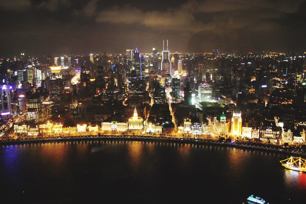 illuminated, night, city, water, building exterior, waterfront, cityscape, architecture, built structure, reflection, river, sky, skyscraper, residential district, light, sea, residential building, crowded, modern, city life