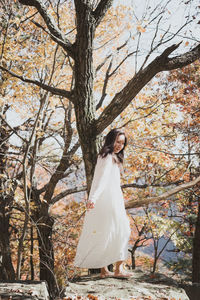 Rear view of woman standing in forest