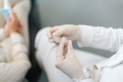 Midsection of doctor holding dentures