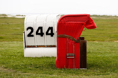 Scenic view of hooded beach chairs on grass against clear sky