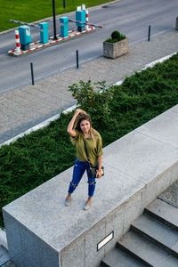 High angle portrait of woman standing by staircase