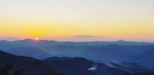 Scenic view of silhouette mountains against sky during sunset