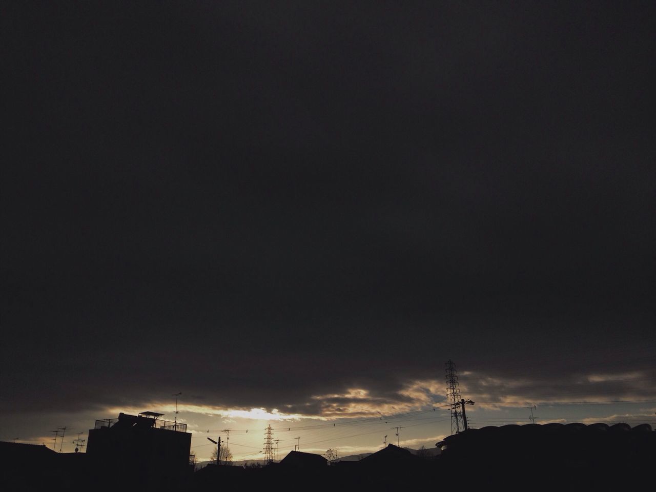 silhouette, sky, low angle view, building exterior, built structure, architecture, power line, electricity pylon, sunset, dusk, cloud - sky, nature, beauty in nature, electricity, outdoors, house, tranquility, no people, scenics, copy space