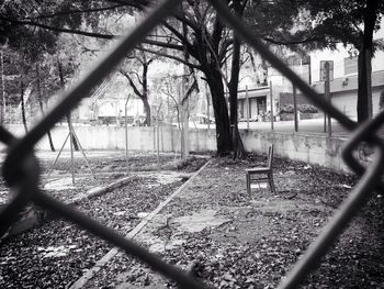 Fence by trees against sky