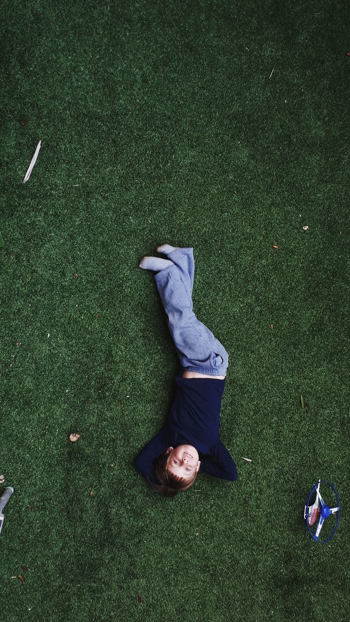 HIGH ANGLE VIEW OF MAN LYING ON FIELD