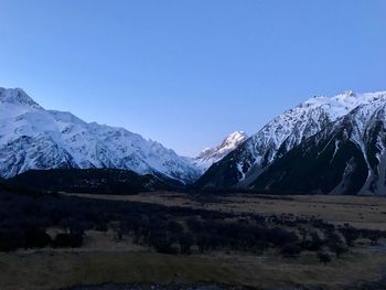 Scenic view of snowcapped mountains against clear blue sky