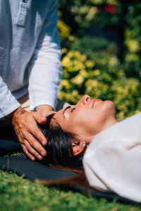 Woman in reiki spiritual healing session. reiki therapist holding hands above heart chakra 