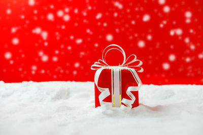 Close-up of christmas present against red background