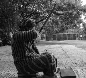 Side view of woman aiming with bow and arrow at target