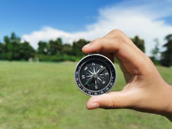 Cropped hand holding navigational compass