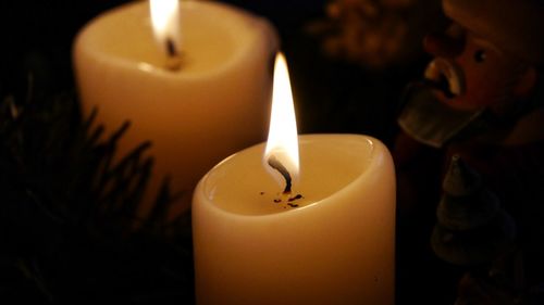 Close-up of tea light candle in darkroom