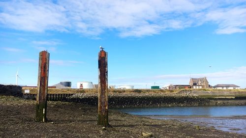 Buildings by sea against sky