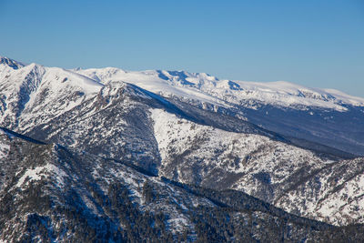 Scenic view of snowcapped mountains against clear blue sky