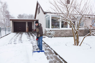Man standing on snow covered house