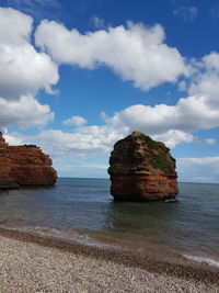 Rocks on sea shore against sky