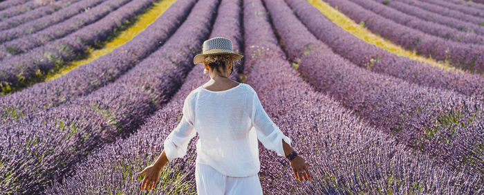 Rear view of woman walking on field