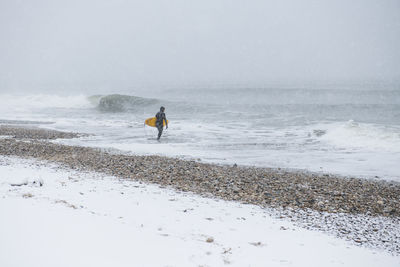 Man going surfing during winter snow