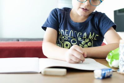 Midsection of boy sitting on table