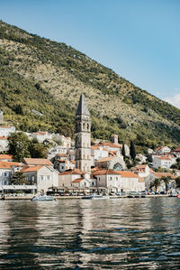 Buildings at waterfront against sky