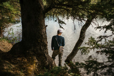 Man fishing in a lake among the trees