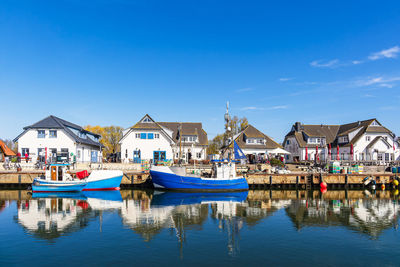 Boats in water against clear blue sky