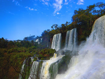 Scenic view of waterfall against sky