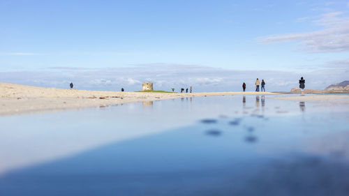 People on beach against sky