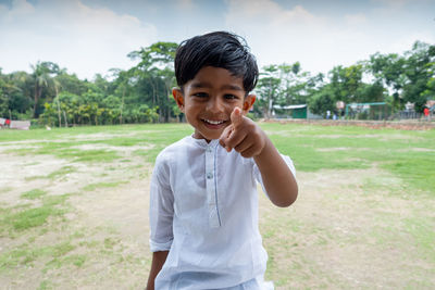 Portrait of happy boy standing on field