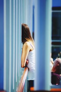Rear view of woman standing by window