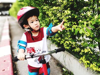 Cute boy gesturing on footpath