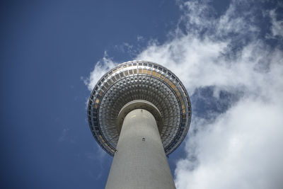 Low angle view of communications tower in city against sky