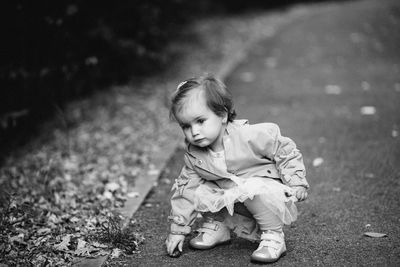 Cute baby girl sitting on land