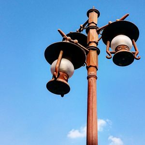 Low angle view of street light against blue sky