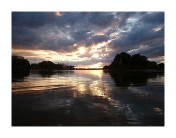 Scenic view of river against sky at sunset