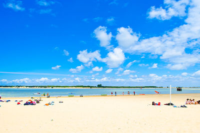 People on beach by sea against sky