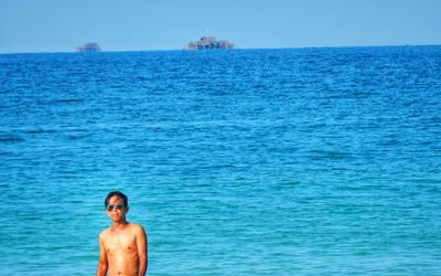 Portrait of shirtless man standing in sea