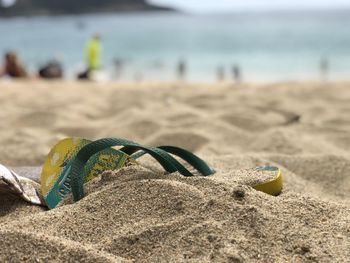 Close-up of yellow shoes on beach