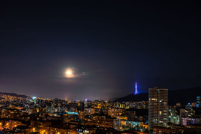 High angle view of illuminated buildings against sky at night