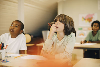 Male students concentrating at desk in classroom