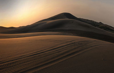 Scenic view of desert against sky during sunset