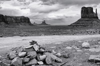 View of rocks on land against cloudy sky