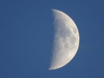 Low angle view of moon against clear blue sky