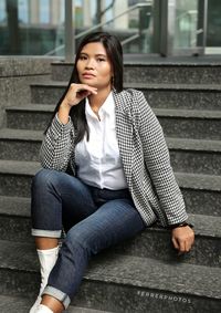 Woman in a  seating pose in a street  fashion photography 